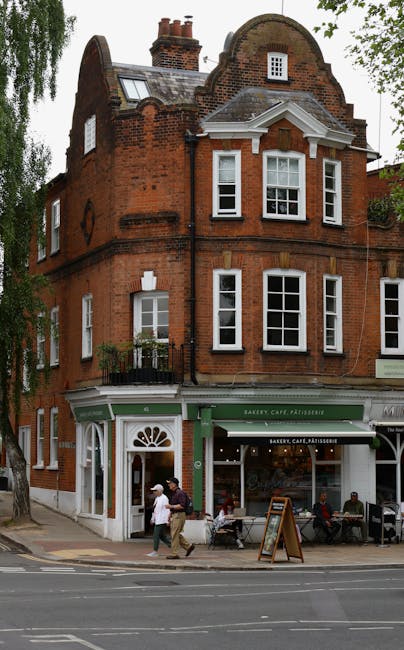 The image shows a corner building in Hampstead Heath with a friendly flower shop on the ground floor, featuring a green and white facade and large glass windows displaying floral arrangements. Outside